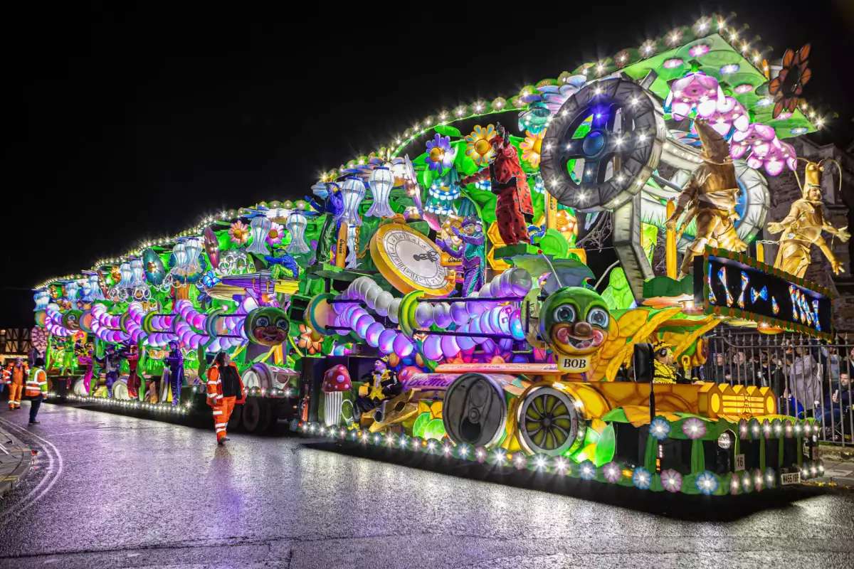 A brightly illuminated carnival cart moving through Bridgwater at night