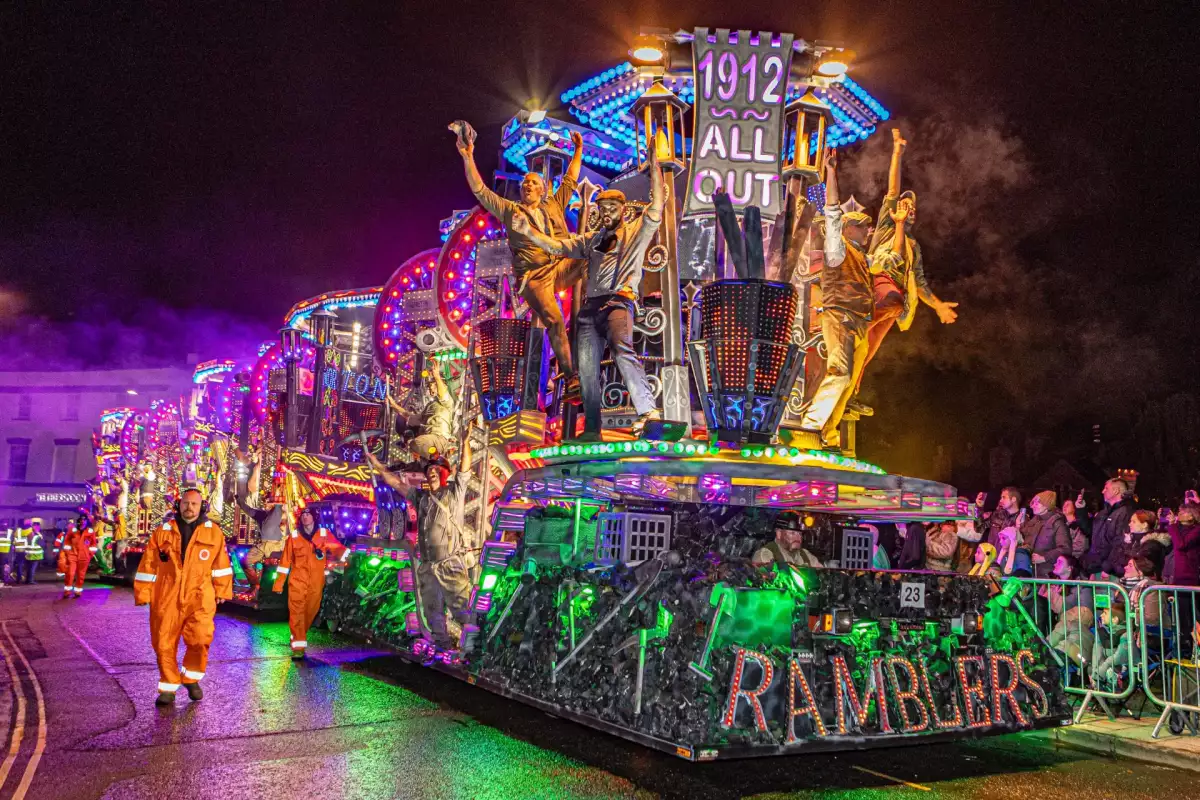 The illuminated Ramblers carnival cart passing spectators at night